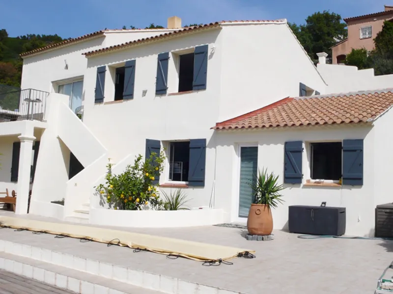 Villa méditerranéenne à la façade rénovée en blanc avec volets bleus